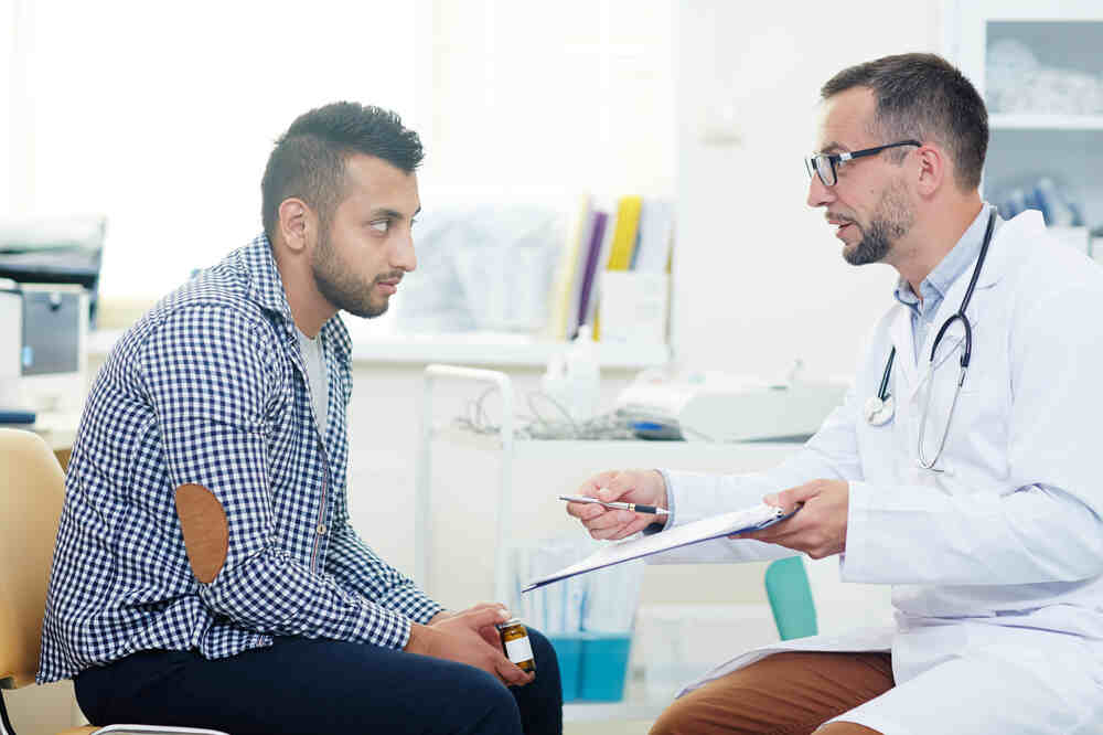 Male doctor talks with male patient. Medazur Medical Clinic in Leytonstone.