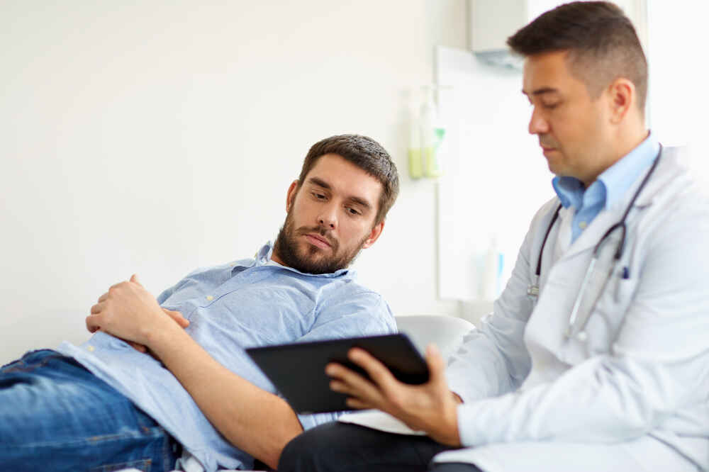 Male doctor with male patient explains about the upcoming treatment. Medazur Medical Clinic in Leytonstone.