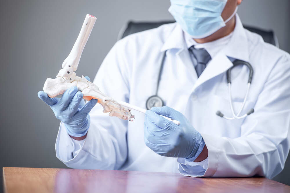 Orthopaedic Doctor Looking at Fake Ankle Bone. Medazur Medical Clinic in Leytonstone.